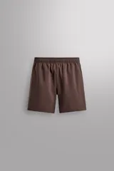 Pantalones deportivos cortos de tejido técnico ligero y elástico, con cintura elástica ajustable, bolsillos frontales y aberturas laterales en el bajo.