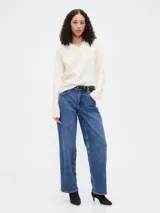 Buzo de punto con cuello en V, manga larga y puños acanalados. Diseño holgado y minimalista.