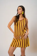 Vestido corto tejido a rayas verticales color amarillo y marrón, con escote redondo y mangas sisa. Incluye cinturón marrón con hebilla dorada.