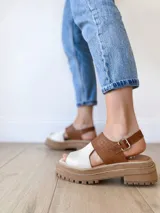 Sandalias de cuero color camel y crudo, con plataforma track y hebilla ajustable.