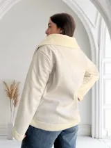 Campera corta color crudo de ecocuero con interior de corderito, cierre frontal con cremallera y bolsillos laterales.