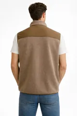 Chaleco sin mangas de tejido técnico color beige, con cierre frontal completo y bolsillo en el pecho con cierre en contraste color negro.