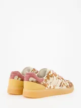 Championes de estilo urbano con estampado animal print tipo vaca en tonos marrones y beige. Presenta detalles en gamuza rosada en el talón, cordones rosados y suela de goma color caramelo.
