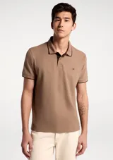 Remera polo blanca de manga corta, con cuello camisero y ribetes grises en cuello y puños. Cuenta con cierre frontal de botones y un pequeño logo bordado en el pecho.
