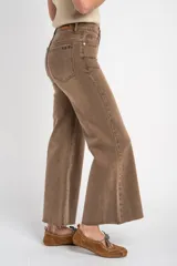 Pantalón de jean estilo flare con efecto lavado, tiro alto y corte al cuerpo que se ensancha en la parte inferior. Posee bolsillos delanteros y traseros, con terminación deshilachada en el bajo.