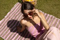 Pañuelo cuadrado multifunción de algodón liviano con rayas teñidas a mano en tonos rosados y amarillo.