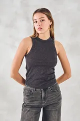 Musculosa ajustada al cuerpo confeccionada en tejido con acabado de lurex brillante. Presenta cuello redondo alto y diseño sin mangas con sisas pronunciadas.