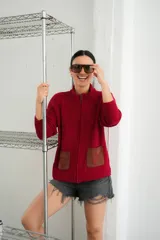 Campera tejida con textura vanizada a rayas horizontales en blanco y negro, con cierre frontal y flecos negros en forma de V en el pecho.