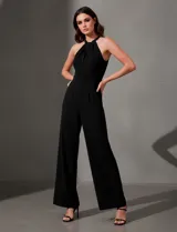 Enterito de crepe negro, corte ancho en pierna, con escote halter entrelazado y abertura en la espalda con cierre invisible y botón.