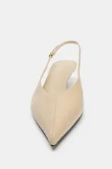 Zapato destalonado de tacón kitten fino, con acabado en punta y tira trasera ajustable con hebilla metálica.