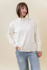 Sweater de tejido de punto color marrón, con cuello alto, corte relajado y terminaciones en rib en puños y cintura. Presenta una hilera de botones metálicos decorativos en uno de los laterales.