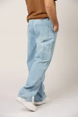 Jean baggy para hombre, color celeste claro, de corte holgado estilo cargo con bolsillos laterales y refuerzos en las rodillas.