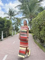 Vestido largo de punto de algodón con diseño rayado horizontal en tonos rojo, verde militar, amarillo claro y rosado, corte recto, manga corta caída, cuello redondo y tajo lateral en el ruedo.