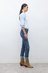 Jean cropped color azul medio, de corte ajustado y ruedo doblado.