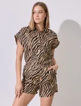 Short de lino con estampado animal print de cebra en tonos marrón y negro. Tiene pretina ancha elastizada y bolsillos inclinados en la parte delantera.