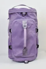 Mochila de tela color lila con bolsillo frontal con cierre y asa de agarre plateada.