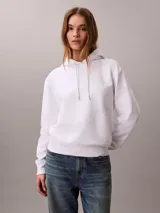 Buzo con capucha Calvin Klein, color blanco, de corte clásico con puños y dobladillo en punto canalé. Presenta cordones ajustables en la capucha y un pequeño logotipo bordado en el pecho.
