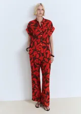 Pantalón largo de corte recto con estampado floral en tonos rojo y marrón, cuenta con cintura elástica y bolsillos laterales.