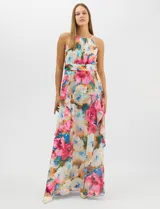 Vestido largo de chifón con estampado floral multicolor. Presenta cuello halter con plisado en el pecho, cintura drapeada y falda amplia con capas asimétricas que aportan movimiento. Incluye forro interior y cierre invisible en la espalda.