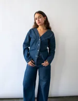 Pantalón de jean color azul oscuro, de corte wide leg y tiro medio-alto. Presenta bolsillos cuadrados frontales y diseño de estilo vintage.