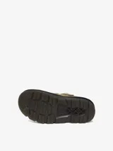 Mule Dr. Martens modelo Zebzag, color beige, confeccionado en gamuza. Presenta una correa ajustable con hebilla metálica, suela híbrida con cámara de aire en EVA y PVC, y las icónicas costuras amarillas de la marca.