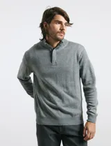 Sweater de punto gris con cuello alto y cierre frontal parcial, de manga larga con puños y ruedo acanalados.