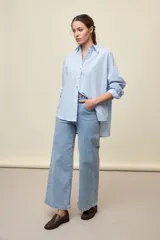 Jean de tiro alto y diseño wide leg con perneras amplias, en color celeste claro, de estilo clásico con cinco bolsillos.