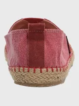 Alpargatas Hush Puppies de estilo slip-on, color bordó con textura de tejido de algodón. Presenta una suela de yute trenzado con costuras decorativas y una etiqueta lateral de la marca.