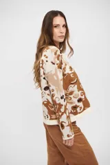 Buzo de tejido de punto con diseño abstracto en tonos tierra, cuello redondo y mangas largas. Presenta terminaciones acanaladas en puños y ruedo.