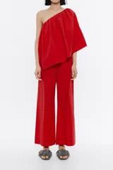 Mono tobillero rojo de algodón, con escote recto, hombro descubierto y volante.