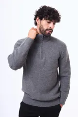 Buzo tejido de punto acanalado en color gris, con cuello alto y cierre frontal parcial. Presenta puños y ruedo elásticos.