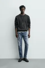 Pantalón de jean corte slim fit, color gris con efecto lavado. Presenta diseño de cinco bolsillos, cierre frontal con cremallera y botón, y tejido elástico.