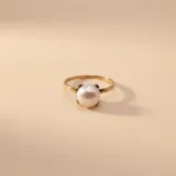 Anillo de oro 9k con una perla de cultivo central engastada en cuatro garras.