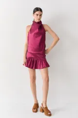 Top halter color marrón brillante, con cuello alto drapeado y espalda media baja.