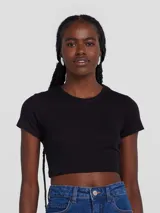 Blusa cropped negra de manga corta, confeccionada en tela acanalada con cuello redondo.