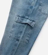 Pantalón de jean corte baggy con diseño cargo, bolsillos laterales amplios y cadena metálica desmontable en la cintura. Presenta un lavado clásico y ajuste tradicional.
