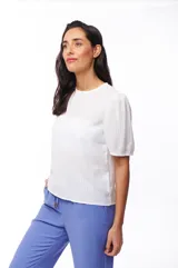 Blusa blanca de poliéster con mangas cortas abullonadas y textura acanalada.