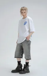 Remera blanca de corte holgado con estampa central en color azul que combina motivos geométricos tipo chakana con figuras de aves dispuestas en círculo.