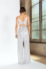 Pantalón de tiro alto confeccionado en tejido de lamé dorado con acabado brillante y corte ligeramente evasé.