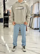 Hoodie de corte boxy fit color gris, con capucha y estampado frontal con la leyenda "Duxon Creative Studios".
