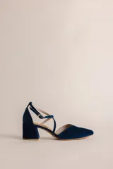 Zapato de tacón bajo color negro, con punta en V, tiras cruzadas en el empeine y cierre de hebilla en el tobillo. El tacón es ancho y mide 5 cm.