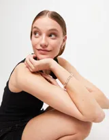 Pulsera de eslabones rectangulares grandes bañada en plata de ley, con cierre de mosquetón y dije rectangular con el logo de la marca grabado.