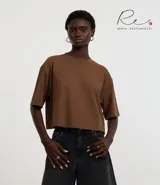 Blusa cropped de corte oversized, confeccionada en algodón, con cuello redondo y mangas cortas.