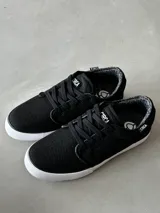 Championes Circa Drifter de corte bajo, color negro con suela blanca. Fabricados en lona y material textil transpirable y resistente a las inclemencias del tiempo.