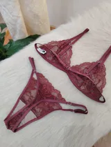 Conjunto de lencería compuesto por un corpiño triangular y una bombacha tipo tanga, ambos confeccionados en encaje bordó con detalles de terminaciones en satén.