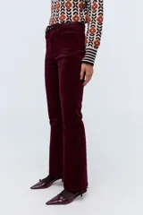 Pantalón de pana color bordó, corte oxford, con cintura alta y cierre frontal con botón y cremallera.