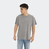 Remera verde oliva de corte oversize, con bolsillo en el pecho y logo de la marca.