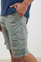 Bermuda cargo de color verde, con diseño funcional de seis bolsillos, incluyendo bolsillos laterales con solapa. Confeccionada en tejido de algodón con elastano para mayor comodidad.