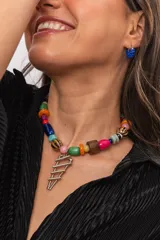 Collar corto de diseño artesanal compuesto por una variedad de cuentas coloridas de cerámica, piedras naturales, cristales checos y madera, con un dije metálico colgante de formas geométricas escalonadas.