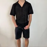 Camisa tejida color crema con diseño calado, cuello tipo polo, manga corta y cierre frontal con botones.